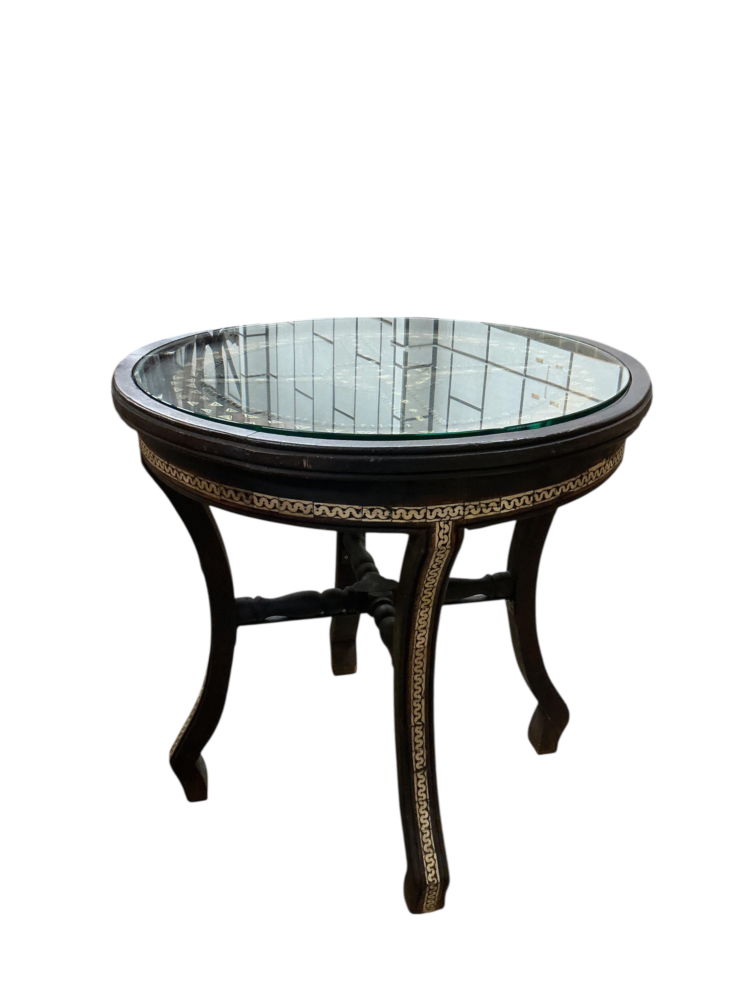 A Moroccan circular studded cedar glass top bistro table, diameter 80cm, height 76cm together with two matching chairs